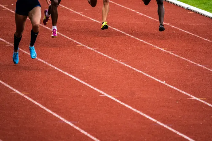 Personnes courant sur une piste d'athlétisme