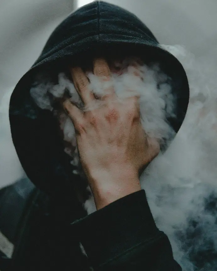 Tête dans la fumée Personne portant un pull à capuche qui a la tête dans la fumée